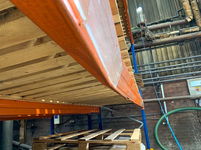 damaged racking beam in a warehouse requiring racking repairs