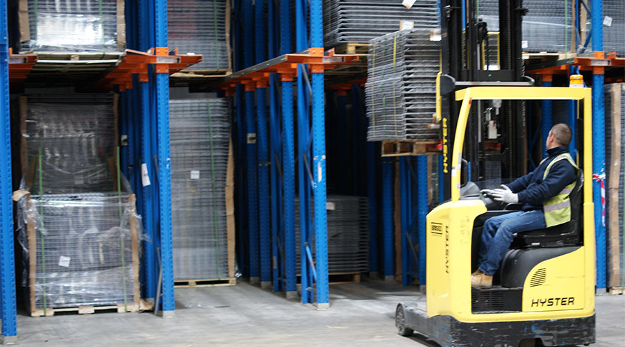 Forklift lifting pallets in drive-in racking